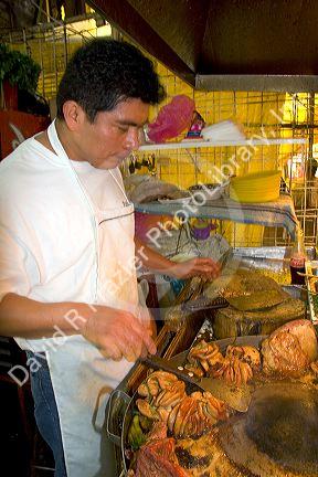 Vendor cooking cow intestine at the Merced Market in Mexico City, Mexico.