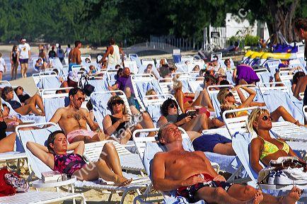 People sunbathe at the beach on Grand Cayman Island.