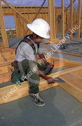 Hispanic construction worker framing a new home in Boise, Idaho.