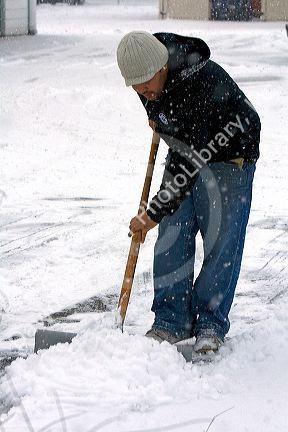 Man shoveling snow from a sidewalk in Boise, Idaho.