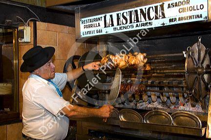 Argentine man cooking meat for a restaurant in Buenos Aires, Argentina.