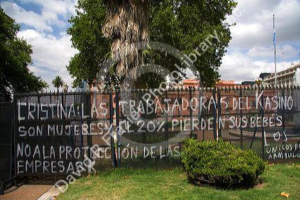 Protest graffiti on a fence in front of the Casa Rosada located on the eastern end of the Plaza de Mayo in Buenos Aires, Argentina.