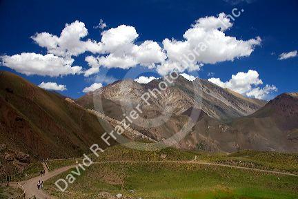 People walk on a trail in the Andes Mountain Range, Argentina.