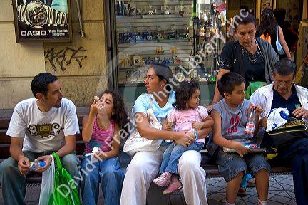 People sit on a bench in Santiago, Chile.