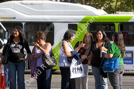 Women wait at a bus stop in Santiago, Chile.