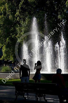People in front of a water fountain in Plaza Independencia in Mendoza, Argentina.