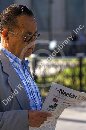 Man reading a spanish language newspaper La Nacion in Valparaiso, Chile.