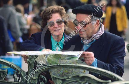 Elderly french couple looks at a map in Paris, France.