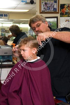 Barber giving a three year old boy a haircut in Tampa, Florida. MR
