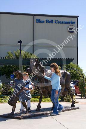 Children play around the Blue Bell Cow and Girl sculpture in front of the Blue Bell Creamery in Brenham, Texas.