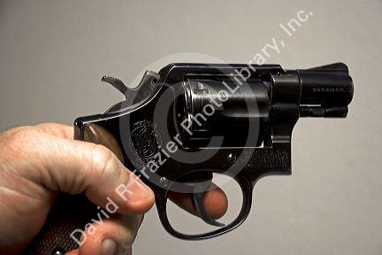 Finger on the trigger of a Smith and Wesson .38 caliber snub nose revolver.