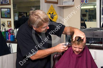 Barber giving a three year old boy a haircut in Tampa, Florida. MR