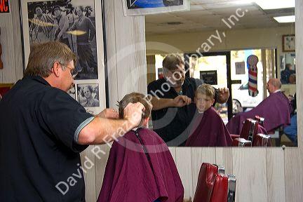 Barber giving a three year old boy a haircut in Tampa, Florida. MR