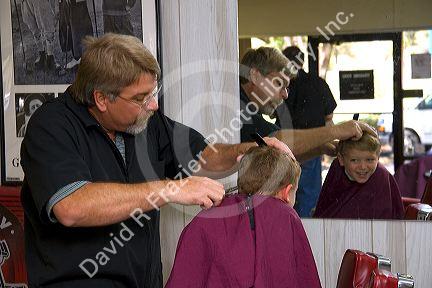 Barber giving a three year old boy a haircut in Tampa, Florida. MR