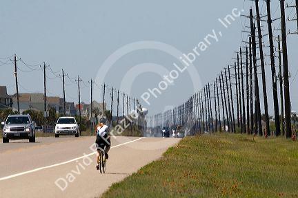 Utility poles line a highway on Galveston Island in Galveston, Texas.