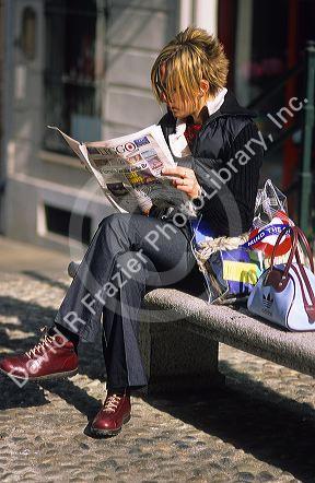 Italian woman reading a newspaper in Torino, Italy.