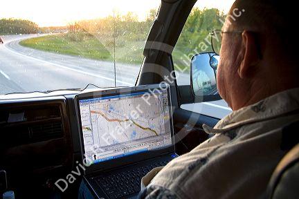 Passenger in a moving vehicle using GPS navigation on a laptop in Michigan. MR