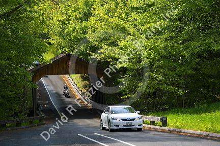 Vehicles driving through a covered bridge in the Sleeping Bear Dunes National Lakeshore located along the northwest coast of the Lower Peninsula of Michigan.