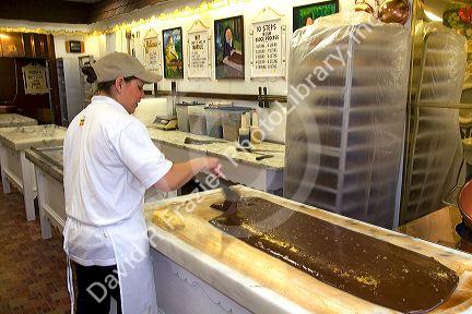 Worker making chocolate fudge at a candy shop in Sault Ste. Marie, Michigan.