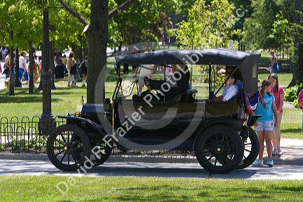 Visitors ride in a Ford Model T in Greenfield Village at The Henry Ford in Dearborn, Michigan.