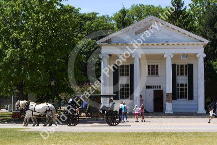 Horse drawn taxi passing the Town Hall in Greenfield Village at The Henry Ford in Dearborn, Michigan.