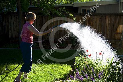 Woman watering flowers in Boise, Idaho. MR