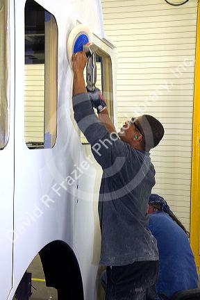 Worker using a power sander at Spartan Motors, a truck chassis manufacturer in Charlotte, Michigan.