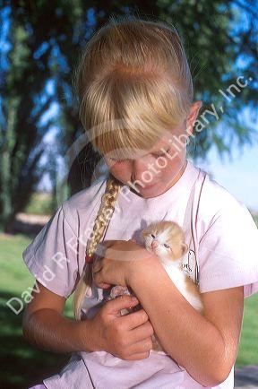Girl holding a kitten.