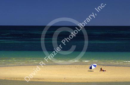Beach scene with woman and umbrella near Adelaide, Australia.