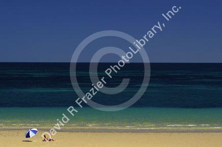 Beach scene with woman and umbrella near Adelaide, Australia.