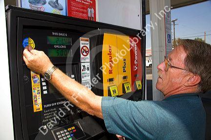 Bureau of Weights and Measures inspector certifies gas pump accuracy with new sticker in Boise, Idaho.