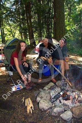Camper roasting a marshmallow in a campfire in the North Cascades National Park, Washington.
