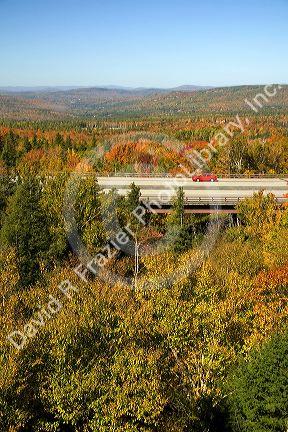 Car driving on Interstate 89 through Franconia Notch State Park with fall foliage, New Hampshire, USA.
