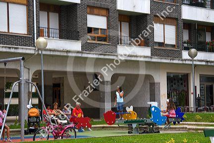 Children use playground equipment in front of an apartment housing unit in Guernica in the province of Biscay, Basque Country, Northern Spain.