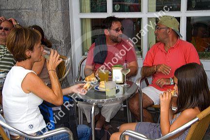 People dine outdoors at a cafe in the town of Lekeitio in the province of Biscay, Basque Country, Northern Spain.