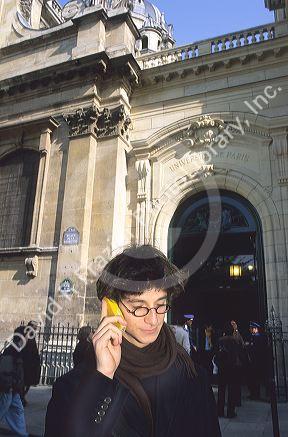 Student using a cell phone in front of the Sorbonne in Paris, France.