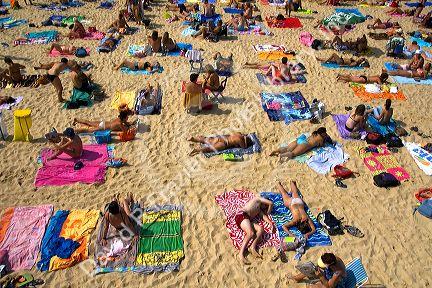 People sunbathe on the beach in the city of Donostia-San Sebastian, Guipuzcoa, Basque Country, Northern Spain.