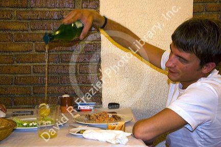 Young man pouring cider into a glass at a restaurant in the city of Donostia-San Sebastian, Guipuzcoa, Basque Country, Northern Spain.