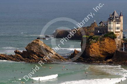 Surfing Cote de Basque below a castle in the Bay of Biscay at the town of Biarritz, Pyrenees Atlantiques, French Basque Country, Southwest France.
