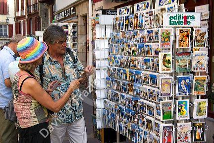 Tourists shop for postcards in the town of Saint-Jean-de-Luz, Pyrenees-Atlantiques, French Basque Country, Southwest France.