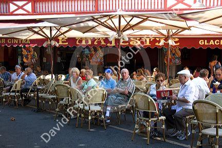 People eating outdoors at a restaurant in the town of Saint-Jean-de-Luz, Pyrenees-Atlantiques, French Basque Country, Southwest France.