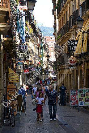 People shopping along a walking street in the city of Donostia-San Sebastian, Guipuzcoa, Basque Country, Northern Spain.