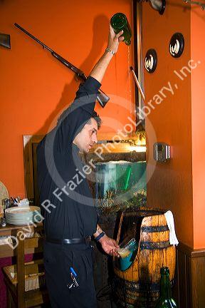 Server pouring cider at a cidereria in the town of Ribadesella, Asturias, northern Spain.