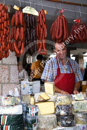 Vendor selling cheese and sausage at an outdoor market in the town of Cangas de Onis, Asturias, northern Spain.