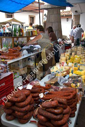 Vendor selling cheese and meats at an outdoor market in the town of Cangas de Onis, Asturias, northern Spain.