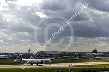 Emirates Boeing 777 airliner on the runway at London Heathrow Airport, England, United Kingdom on a cloudy day.