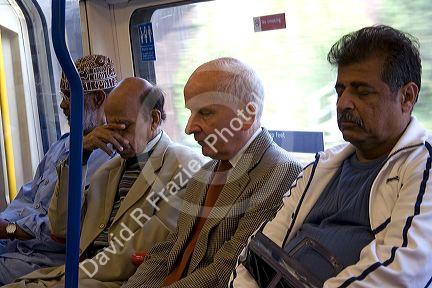 Men sleep on the London Underground transit system in London, England.