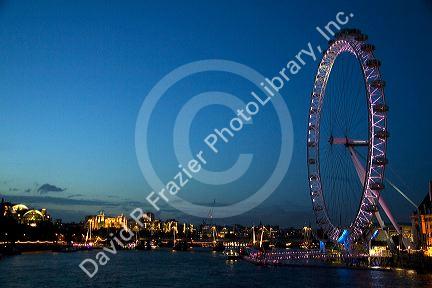 The London Eye at night along the River Thames in London, England.