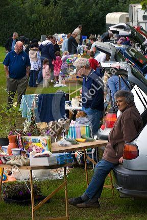 People buy and sell household items at a car boot sale in the market town of Banbury, Oxfordshire, England.