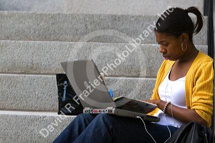 African American female student studying with a laptop on the campus of Harvard University in Cambridge, Greater Boston, Massachusetts, USA. MR